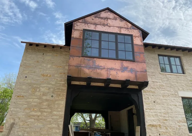 Copper metal panel facade on a stone building for Roof Repair in Chanhassen
